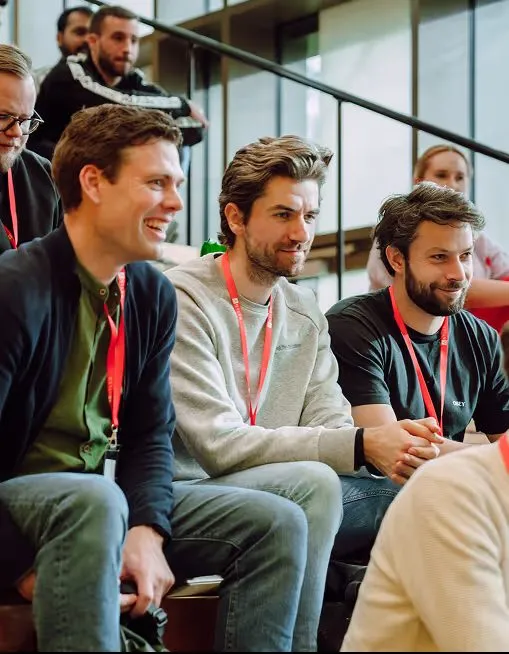 Three co-founders sitting together on steps, laughing