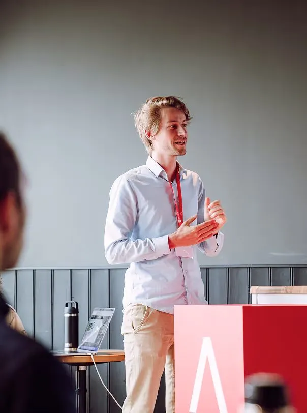 An Antler founder pitching to investors beside the Antler logo